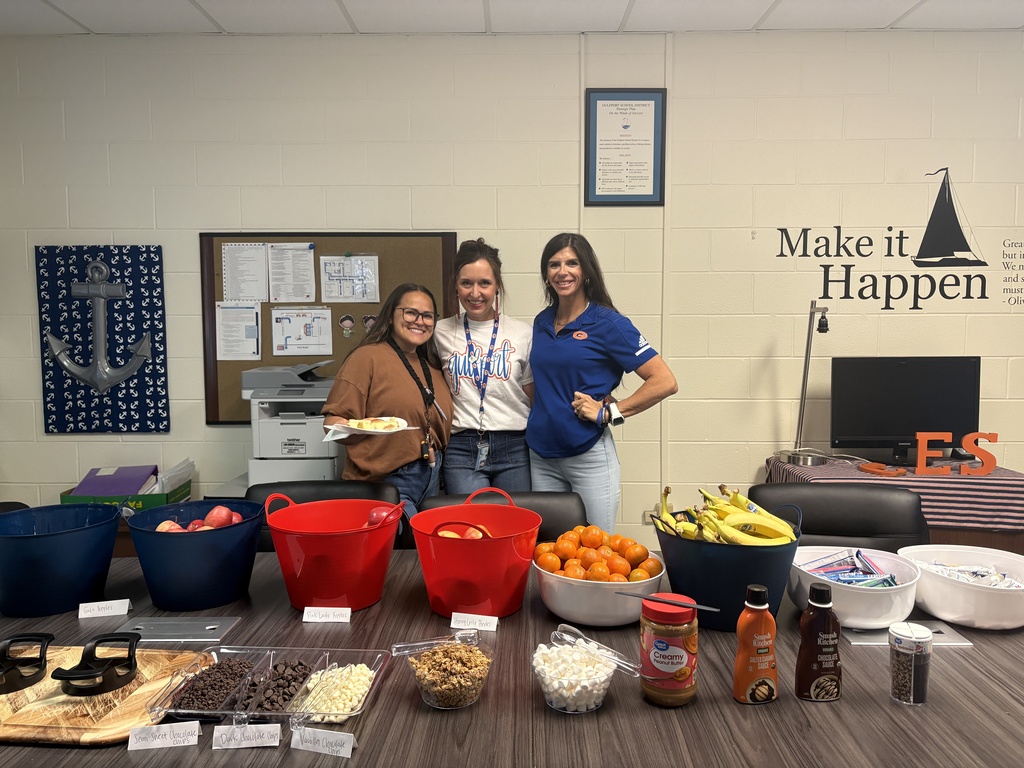 Mrs. Caulder, Mrs. Williams, and Ms. Whitney posing in front of the breakfast bar Ms. Ross set up for our staff