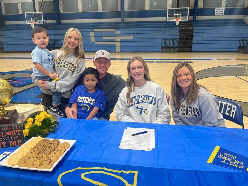 Norah Layman signing with a college to play basketball.