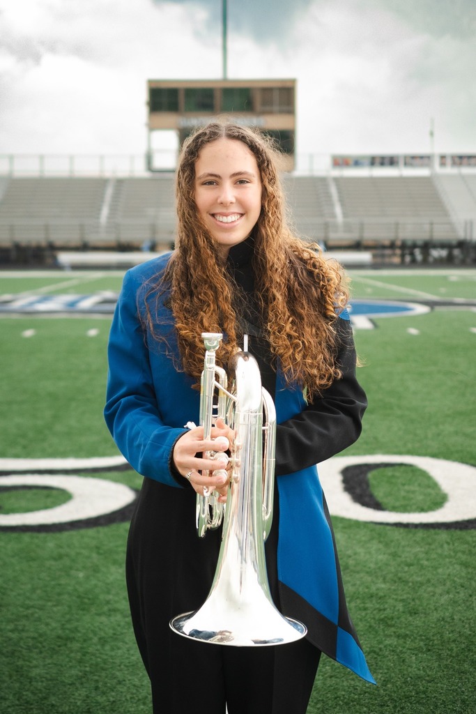  Sarah Smith smiling on the football field holding her euphonium.
