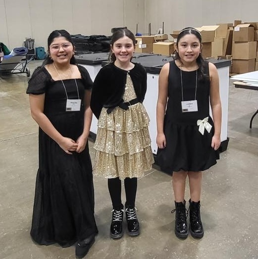 three student singers stand for photo