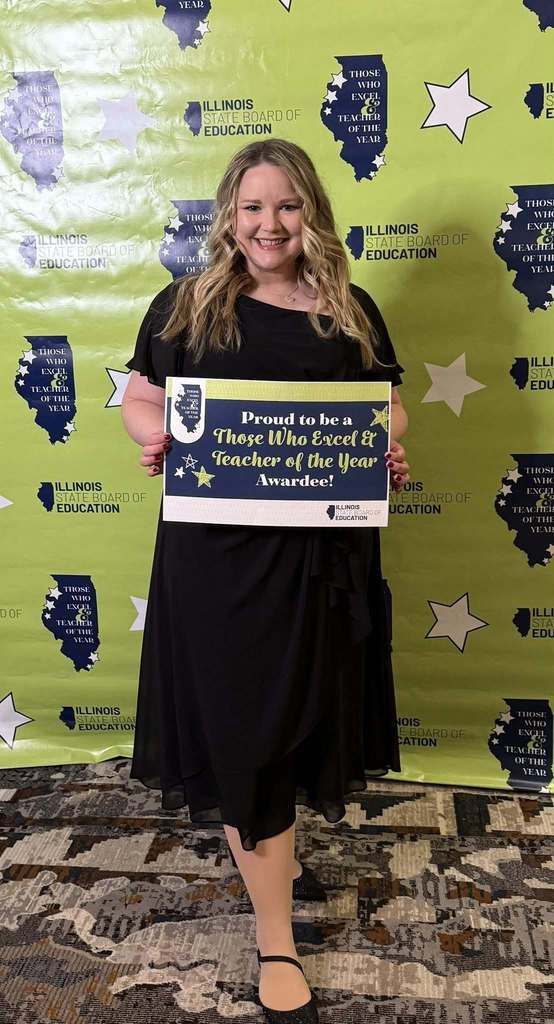 River Trail teacher stands with award at banquet