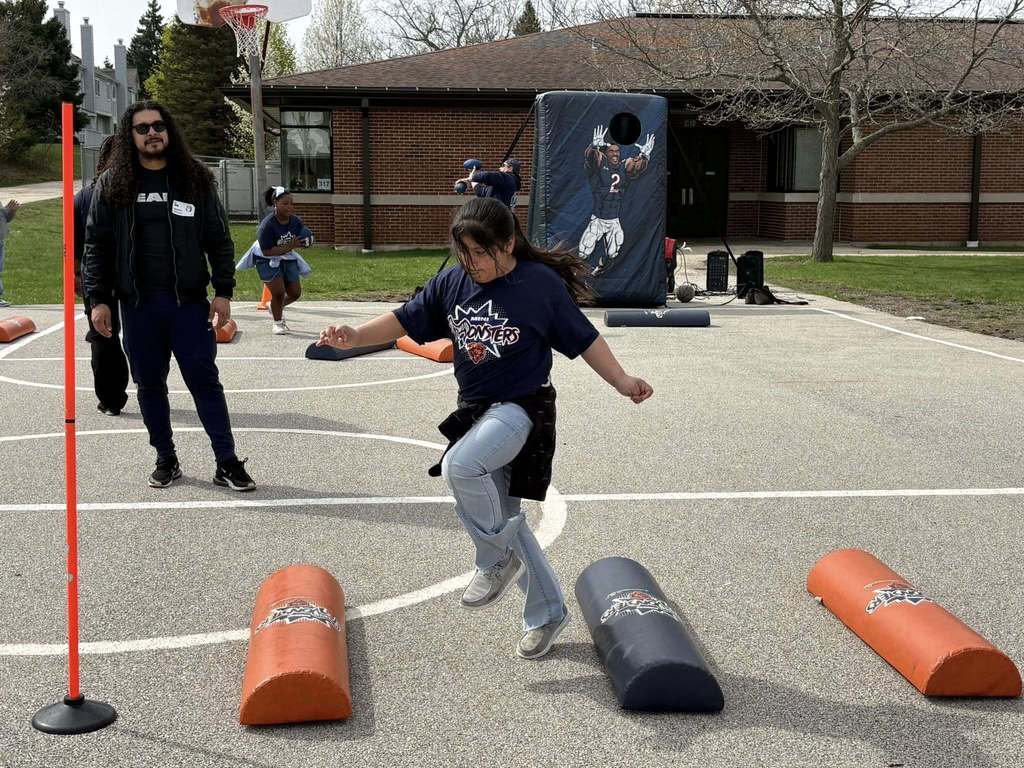 student hops over Chicago Bears training humps on the school playground