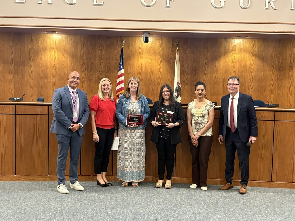 Teacher & staff member of the year holding plaques standing with their principals, the superintendent and the mayor