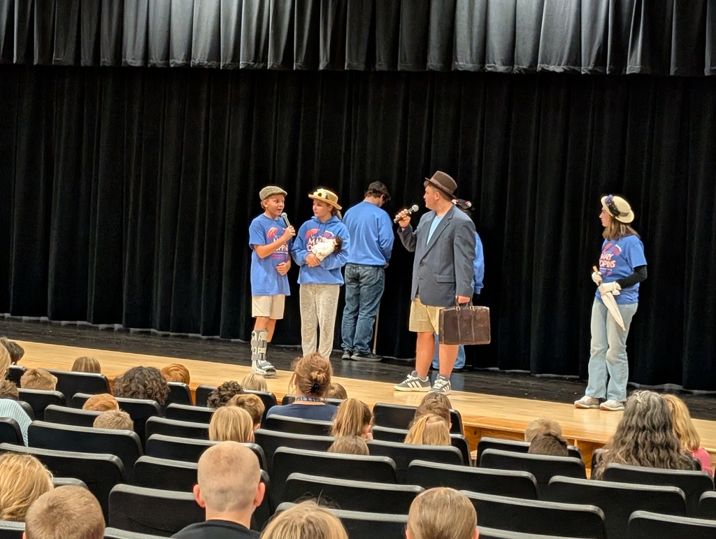 Six students standing and singing on stage
