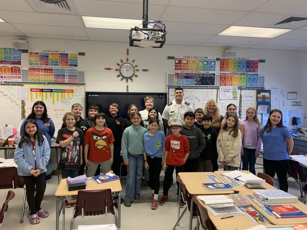 The picture  is Cadet McFarland standing in a classroom with students and teachers. 
