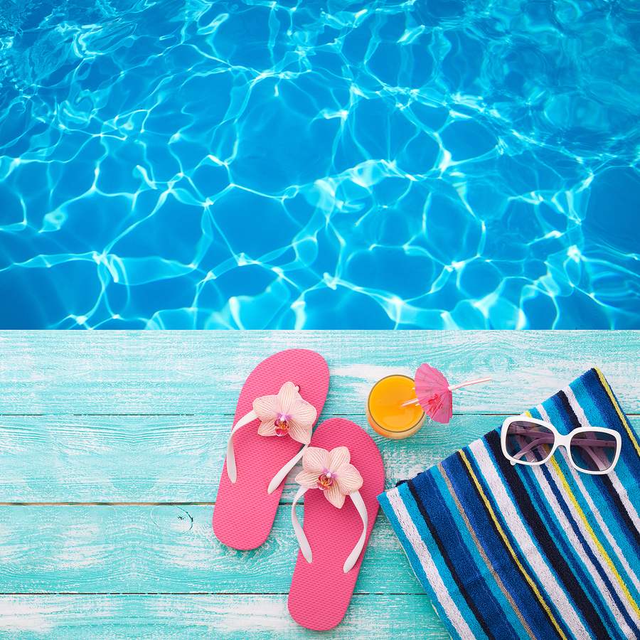 End of year newsletter iage with flip flops, a towel, and pool