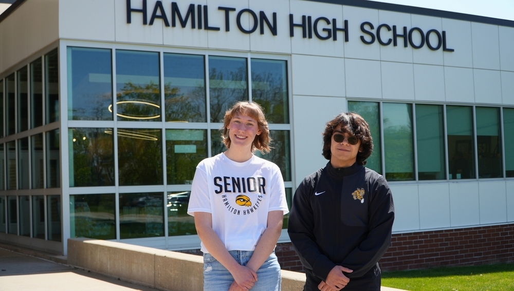 A female and male student smile outside of Hamilton High School.