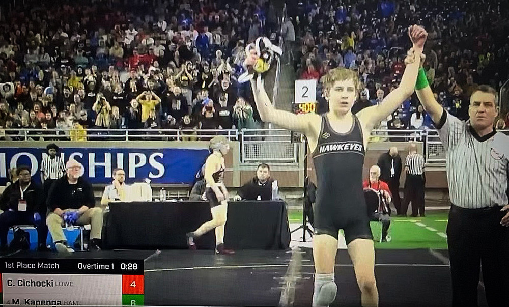 Malachi Kapenga with his arm raised celebrating a state championship.