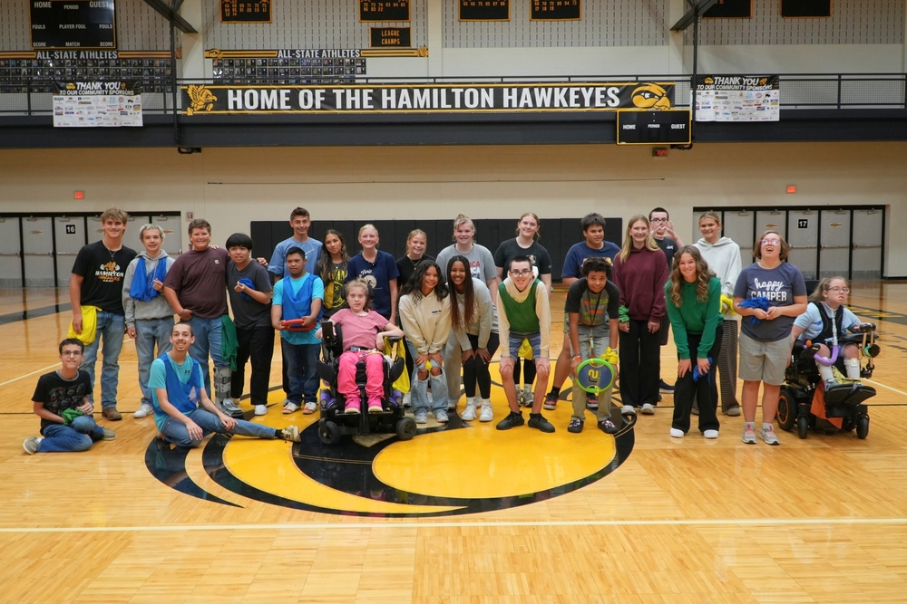 The Unified PE class at Hamilton High School students line up and smile in a gym.