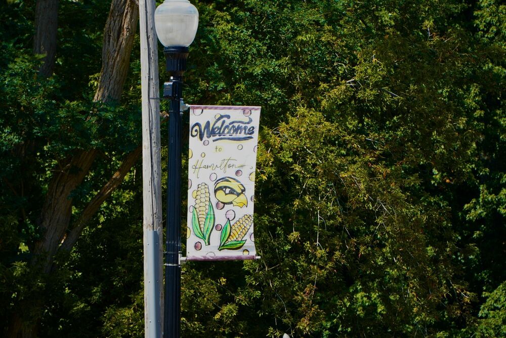 A banner hangs on a light post that says Welcome to Hamilton.