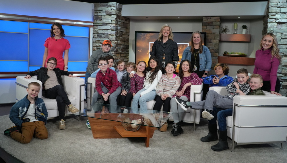 Blue Star Elementary students visiting WZZM 13 studios in a photo with their anchors.