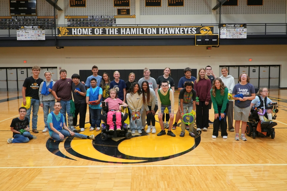 The Unified PE class at Hamilton High School students line up and smile in a gym.