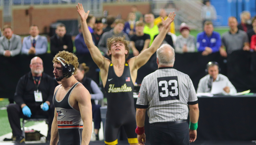 A Hamilton wrestler celebrates with his arms in the air.