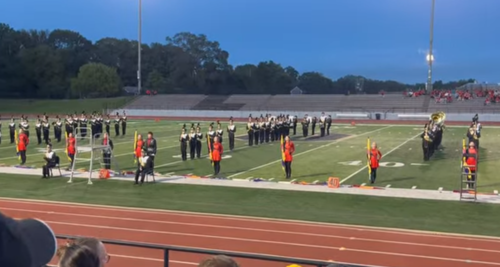 The Hamilton High School marching band on a football stadium turf.
