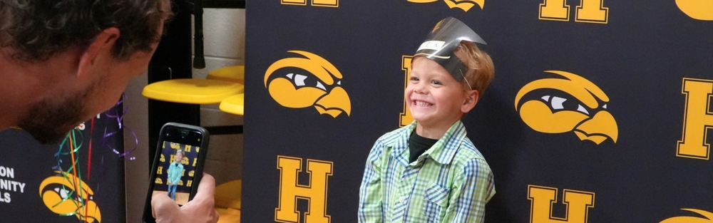 A male student smiles in front of a backdrop.