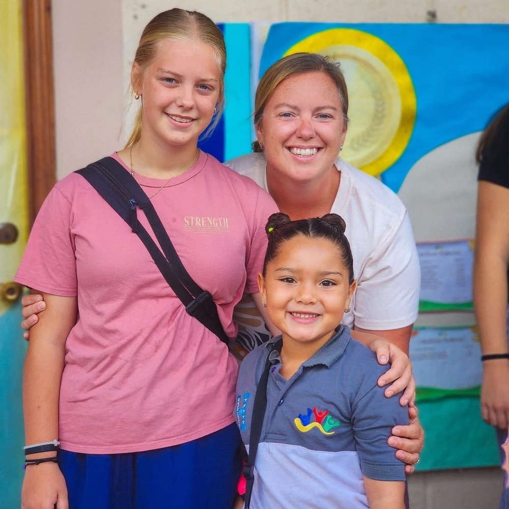 Three females smile.