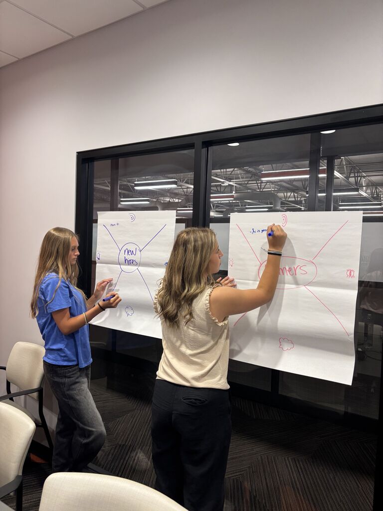 Two female students write on paper.