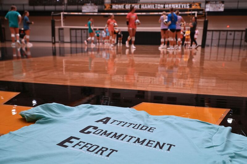 Attitude Commitment Effort shirt on the gym floor.