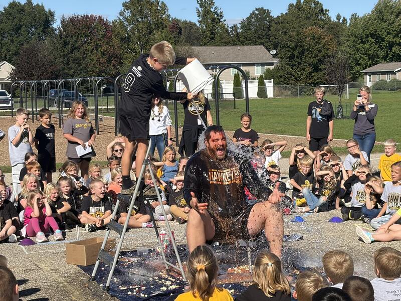 A male student dumps water on a male principal.