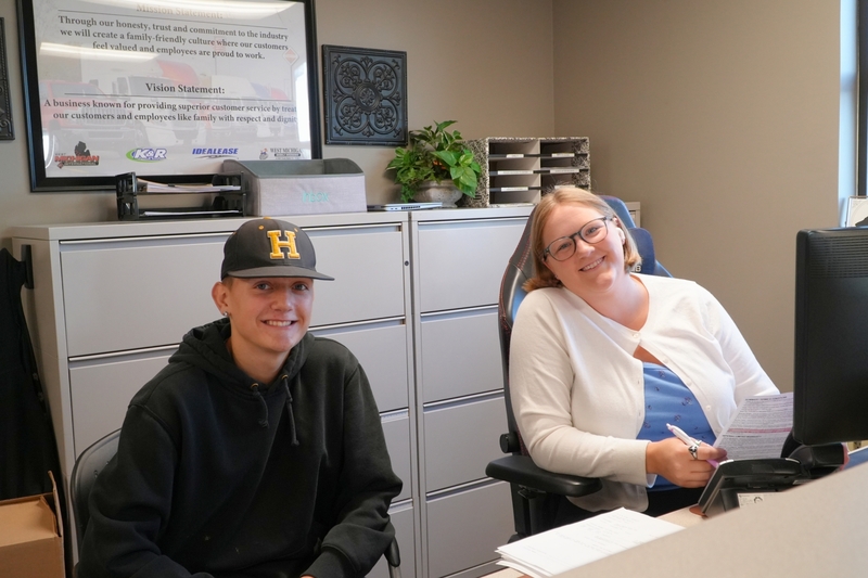 Tony smiles in an office with a female member of the K&R staff.