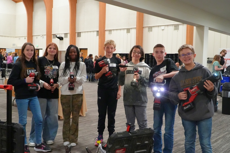 Students hold up tools during manufacturing day.