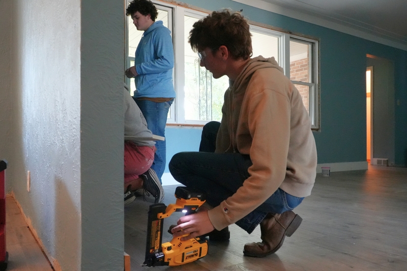 Eli Achterhof helps with flooring in the parsonage home.