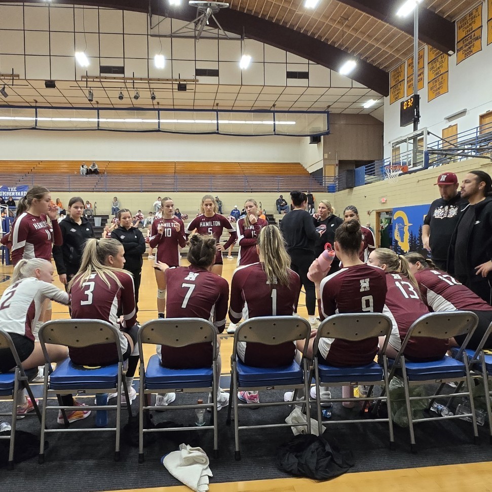 volleyball team sitting on the bench during a game time out