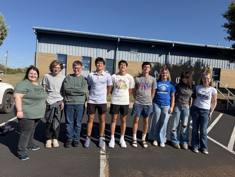 group of teenagers standing together in front of a building 