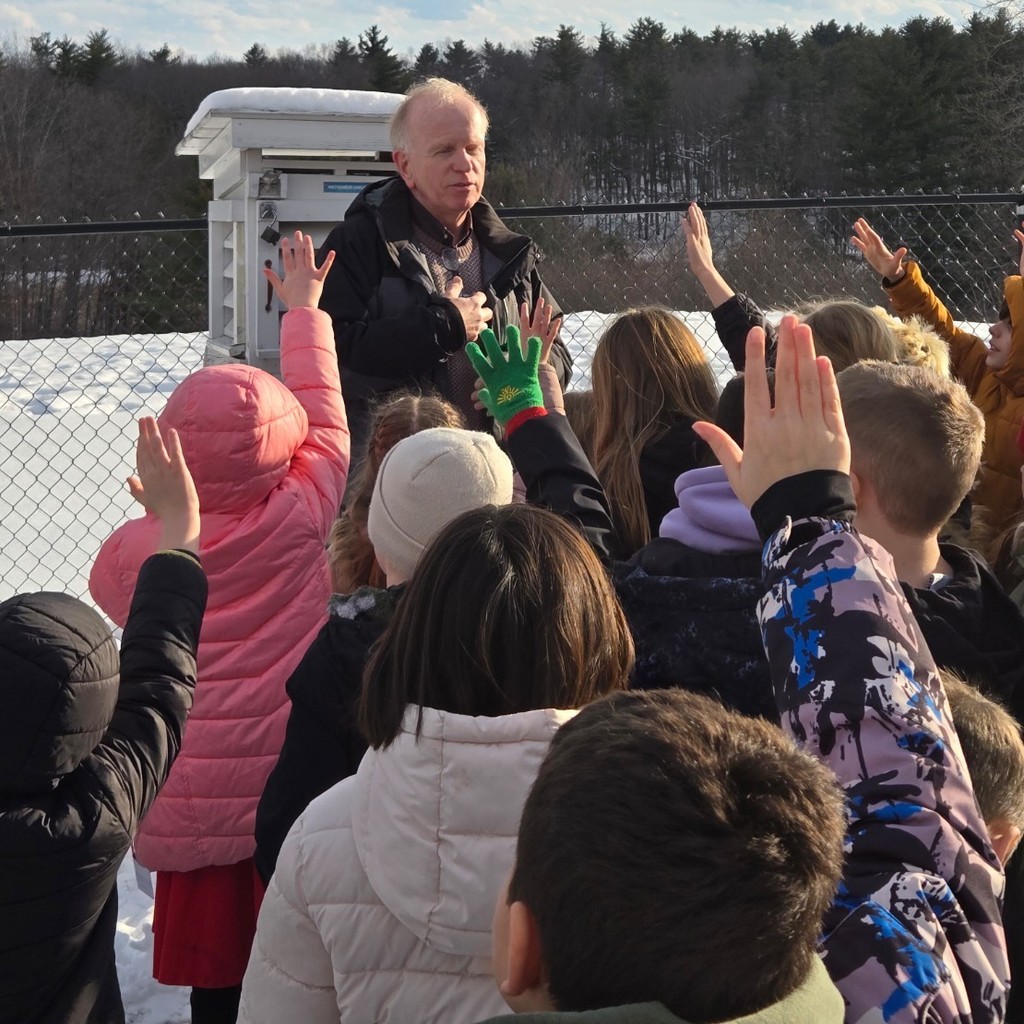 weather man talking to elementary students