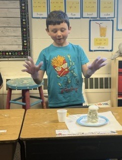 Student watches a baking soda volcano erupt!
