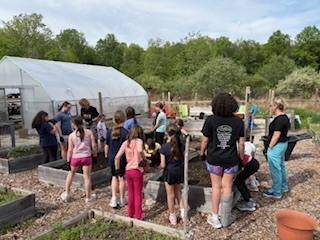 Girls on the run planting at the community garden