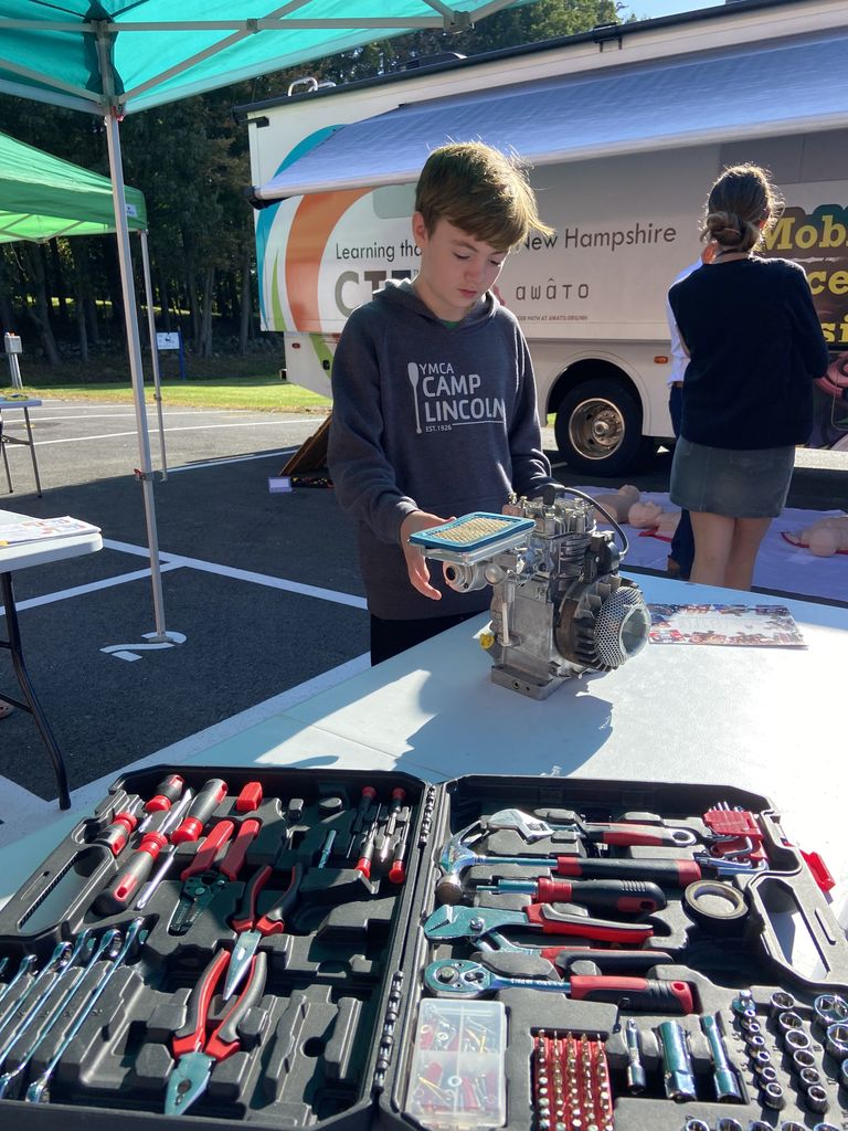 An 8th grade student at the CTE fair checking out a motor