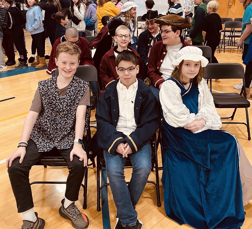 Students wearing old fashioned clothing, waiting to present at assembly