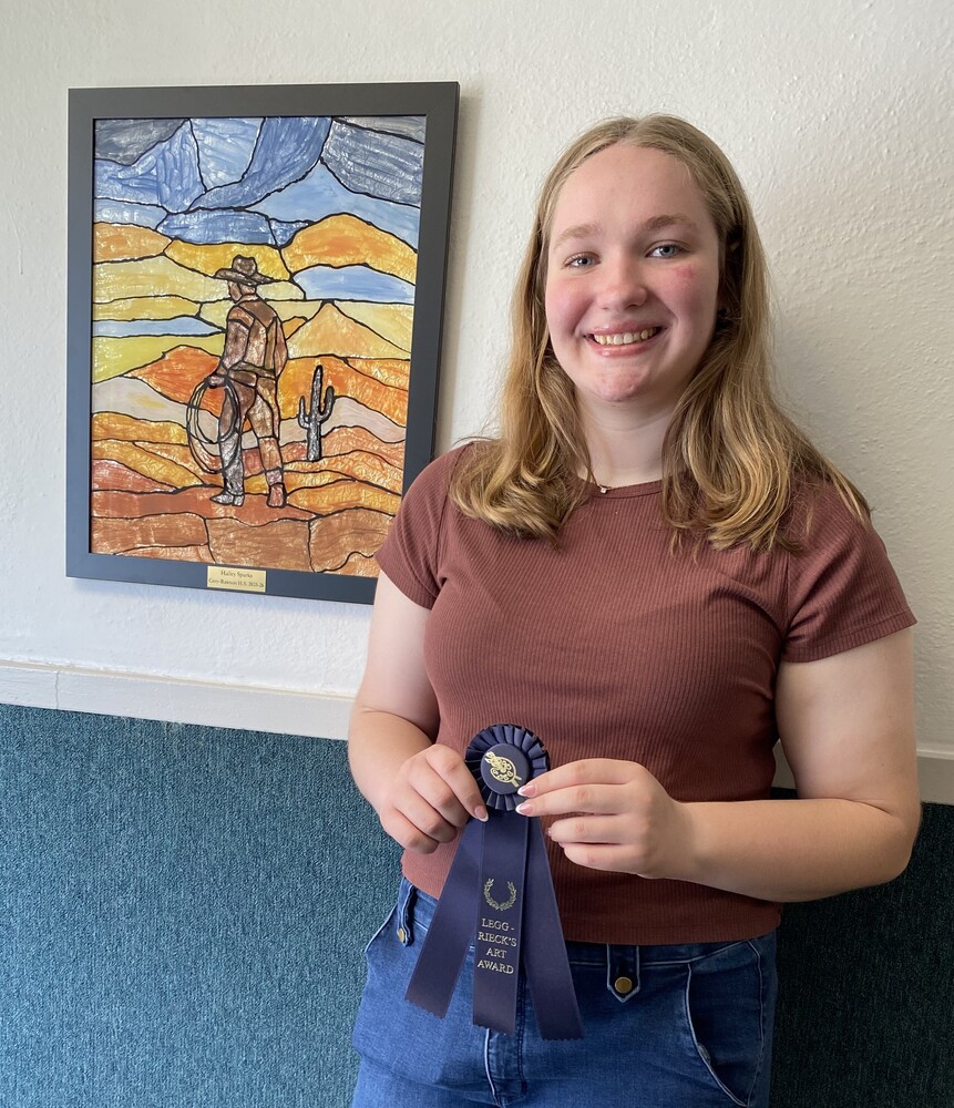 student with ribbon and artwork