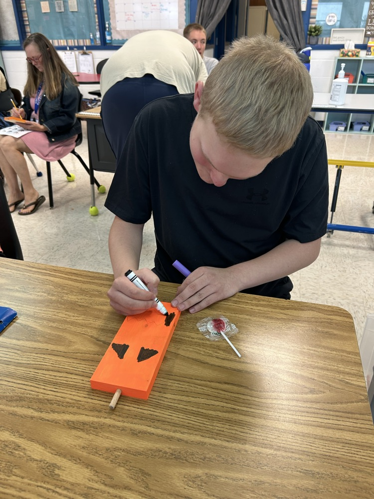 student drawing pumpkin face