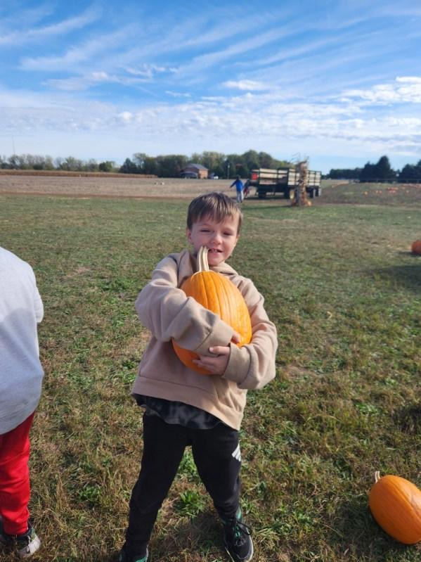student with pumpkin