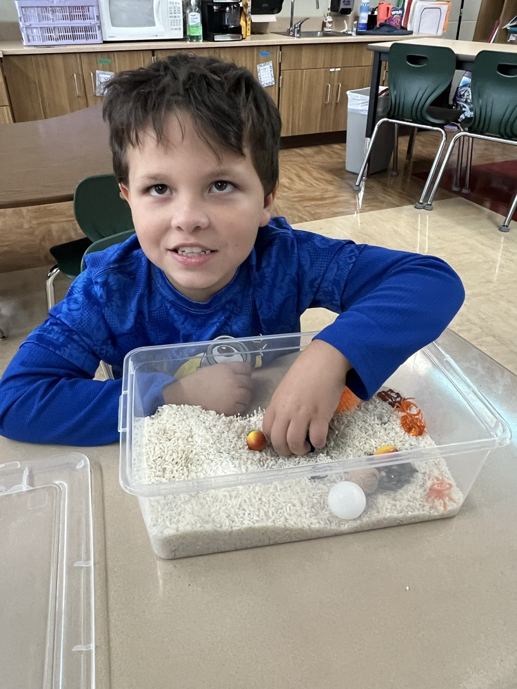 student playing in sensory bin