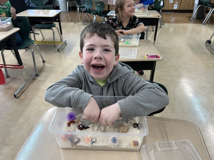 student playing in sensory bin