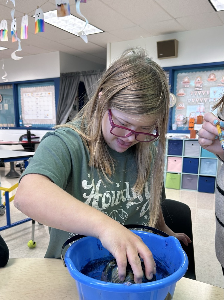 student painting pumpkins