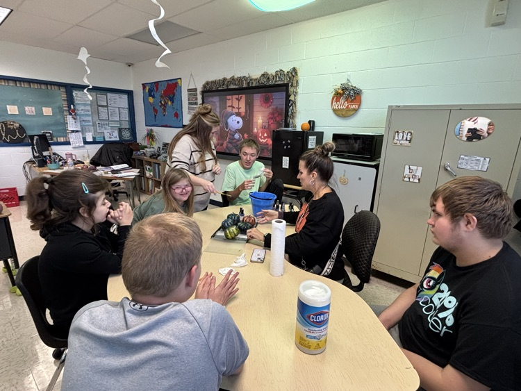 students painting pumpkins