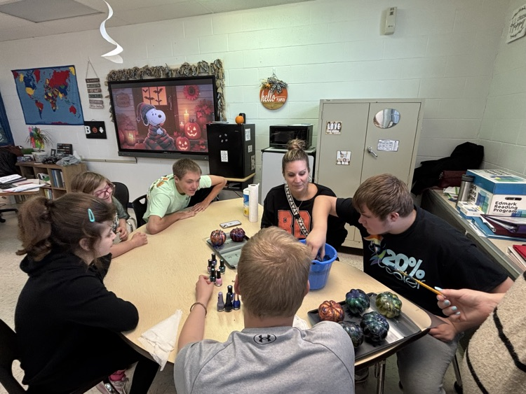 students painting pumpkins