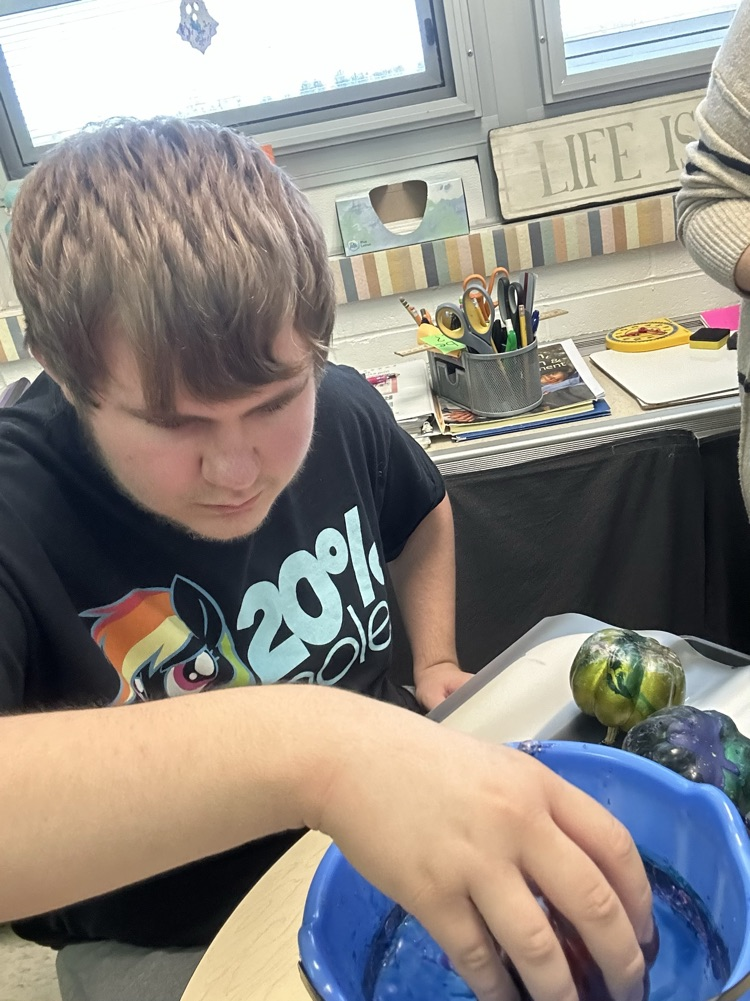 student painting pumpkins