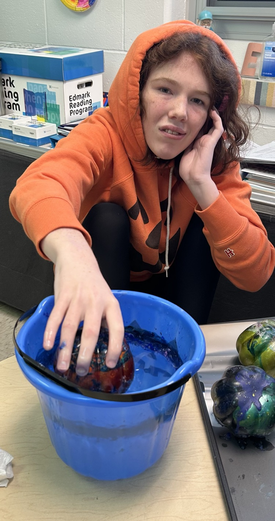 student painting pumpkins
