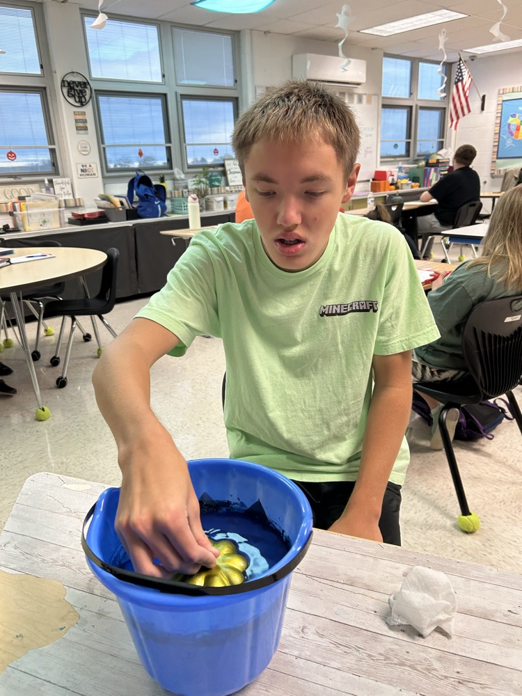 student painting pumpkins