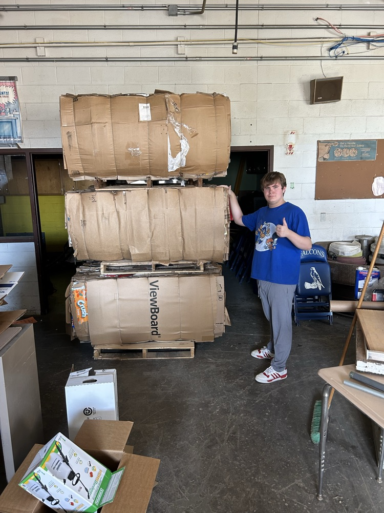 student compacting paper and cardboard