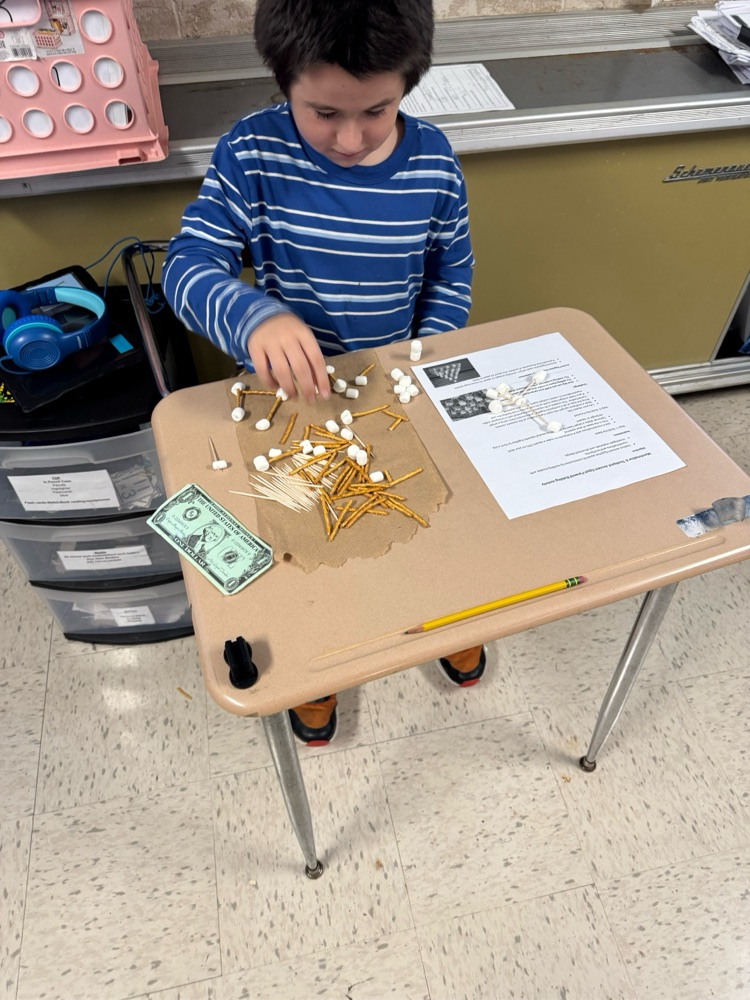 student building with pretzels, sticks and marshmallows