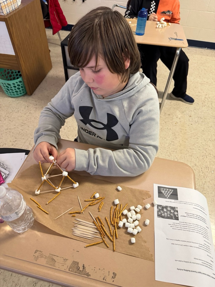 student building with pretzels, sticks and marshmallows