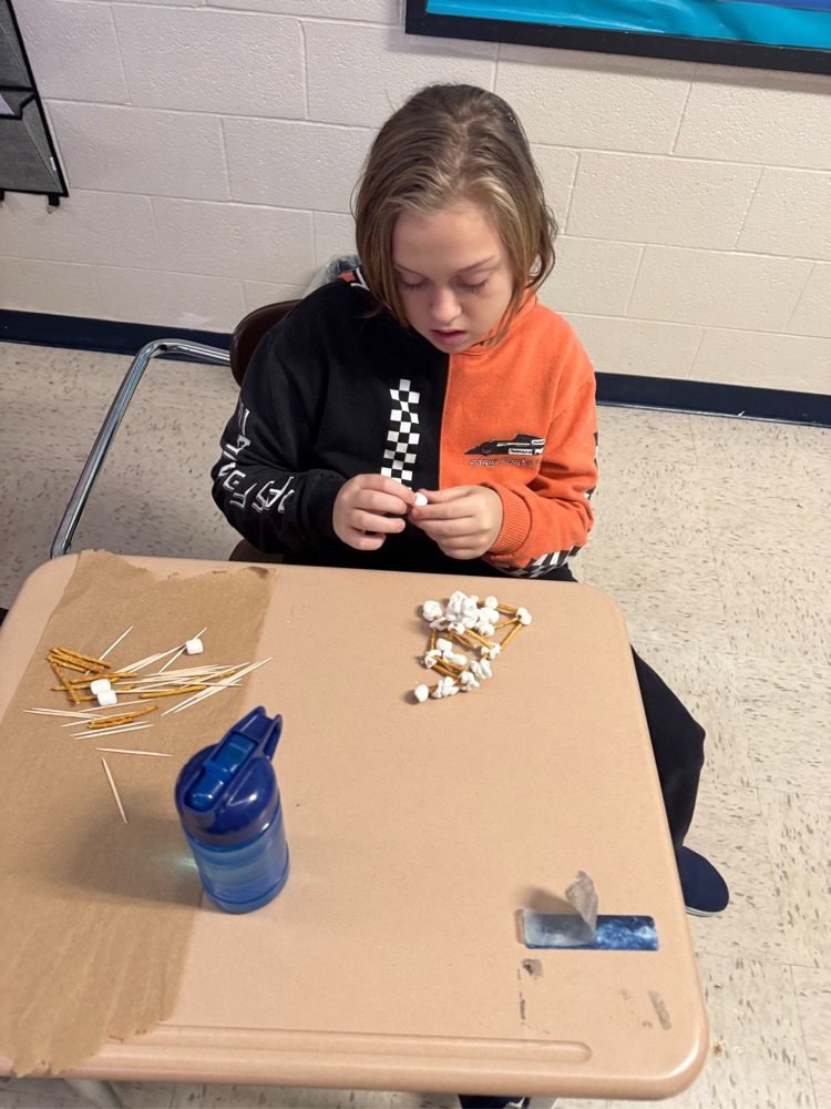 student building with pretzels, sticks and marshmallows