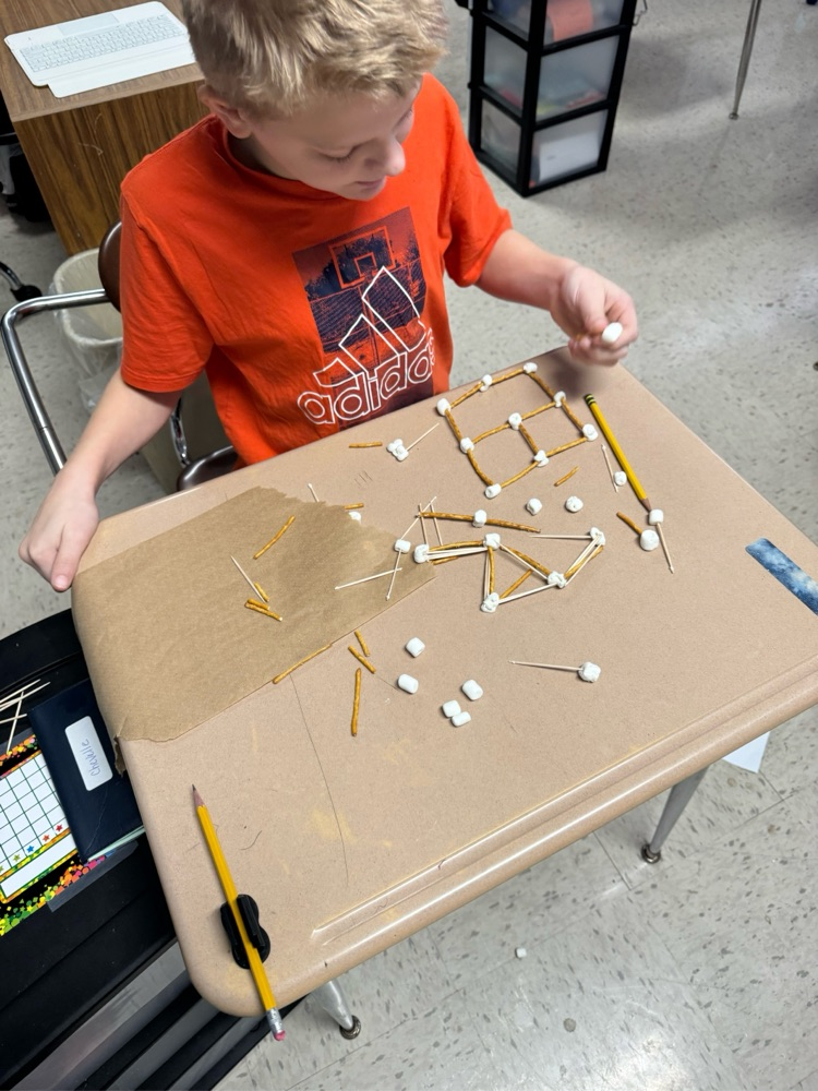 student building with pretzels, sticks and marshmallows