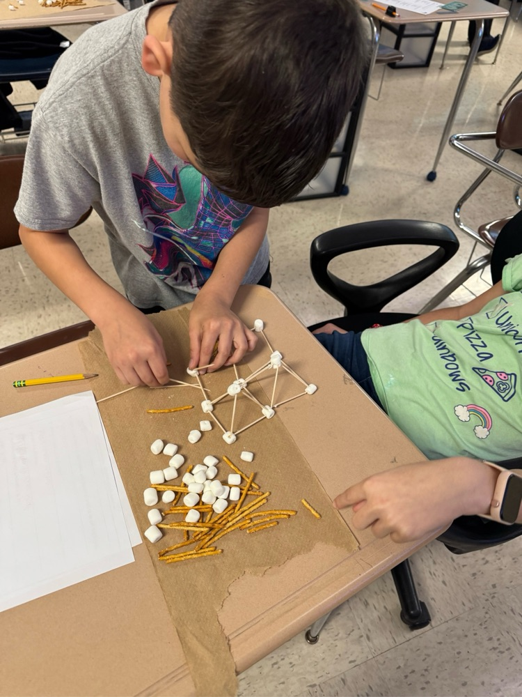 student building with pretzels, sticks and marshmallows